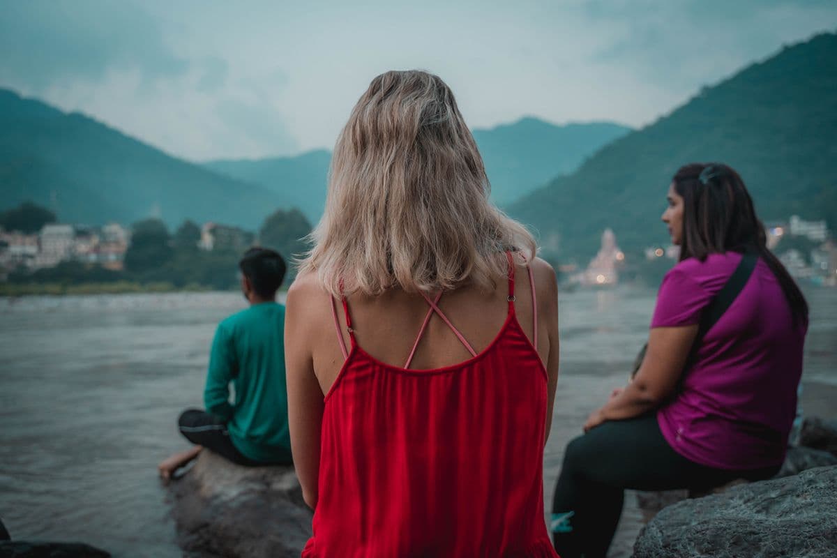 A guided group meditation seated beside the Ganga in Rishikesh at dusk